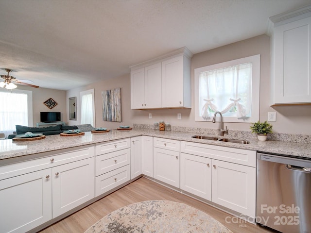 kitchen with light stone countertops, stainless steel dishwasher, sink, light hardwood / wood-style flooring, and white cabinets