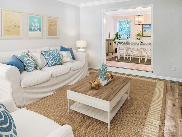 living room featuring crown molding, light hardwood / wood-style flooring, and a chandelier