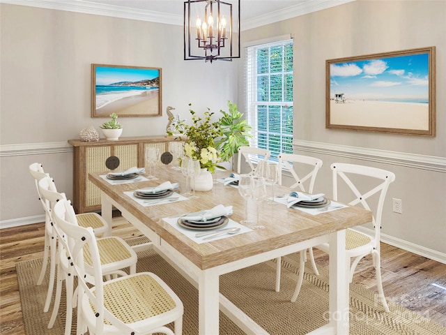 dining room with ornamental molding, a chandelier, and wood-type flooring