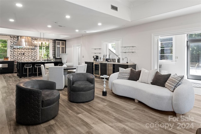 living room with bar, a wealth of natural light, and hardwood / wood-style flooring