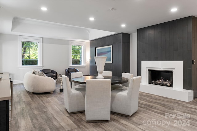 dining area with a large fireplace and light hardwood / wood-style floors