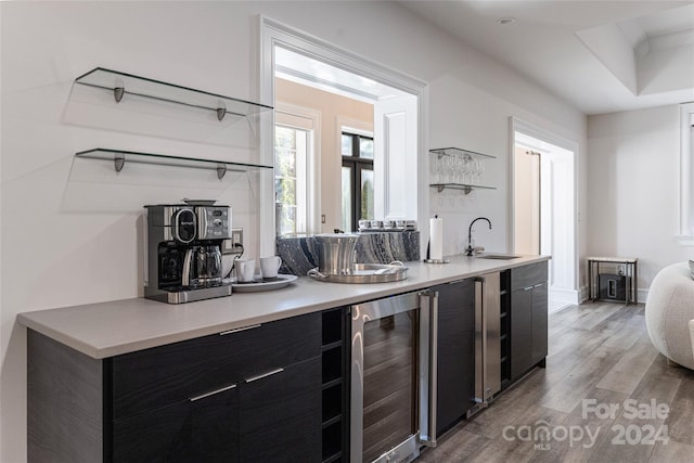 kitchen featuring light wood-type flooring, wine cooler, and sink