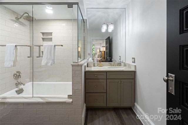 bathroom featuring wood-type flooring, combined bath / shower with glass door, and vanity