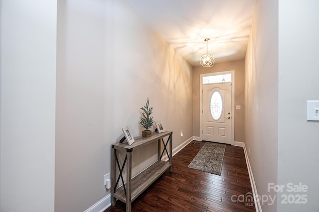 entrance foyer with an inviting chandelier and dark hardwood / wood-style floors