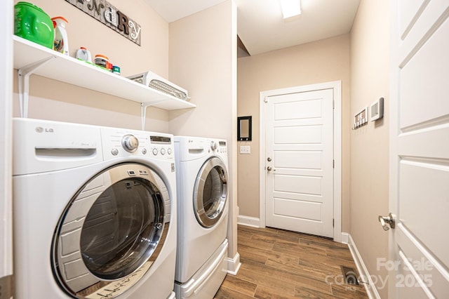 clothes washing area featuring hardwood / wood-style flooring and independent washer and dryer