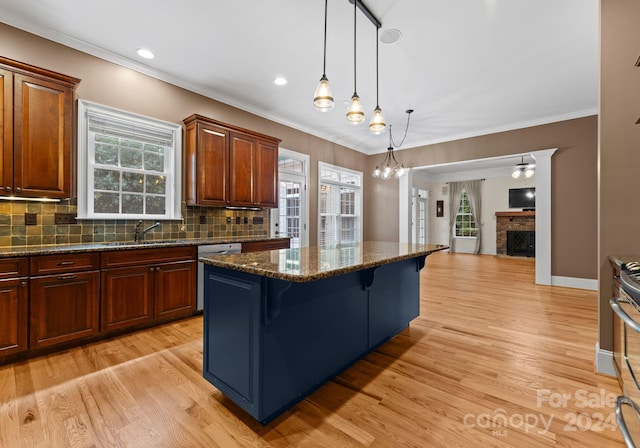 kitchen featuring a breakfast bar, a center island, light hardwood / wood-style floors, and a healthy amount of sunlight