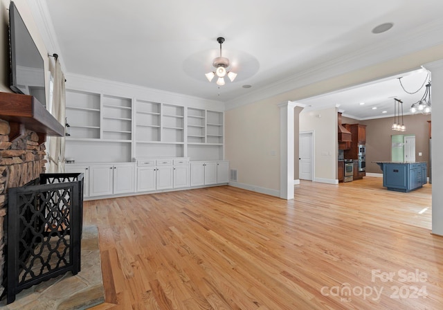 living room featuring ceiling fan, light hardwood / wood-style floors, ornamental molding, and a fireplace