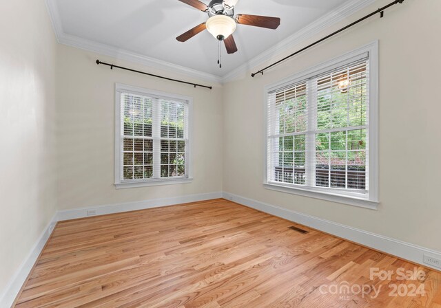 spare room with light wood-type flooring, plenty of natural light, crown molding, and ceiling fan