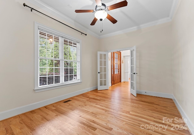 spare room featuring light wood-style floors, french doors, visible vents, and ornamental molding