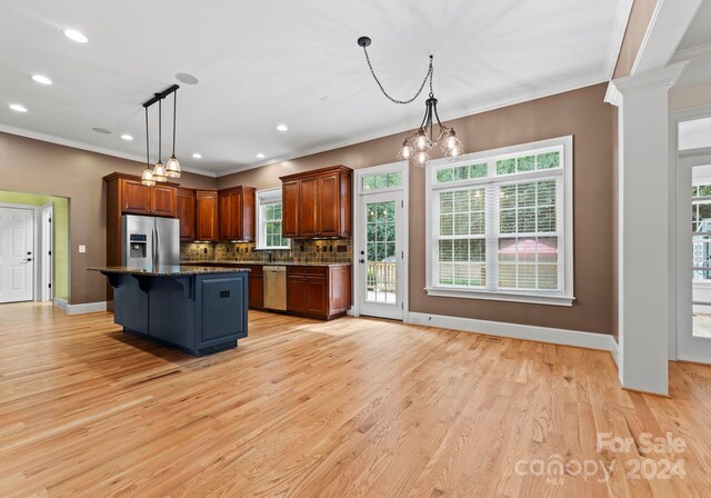 kitchen featuring a center island, light hardwood / wood-style flooring, pendant lighting, and appliances with stainless steel finishes