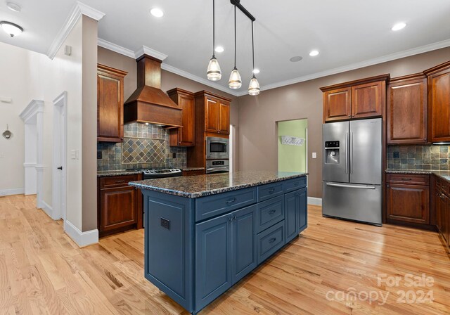 kitchen with custom range hood, stainless steel appliances, light hardwood / wood-style flooring, a kitchen island, and hanging light fixtures