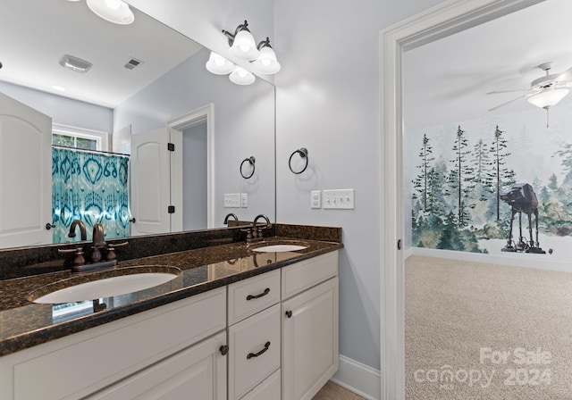 full bathroom with double vanity, baseboards, a ceiling fan, and a sink