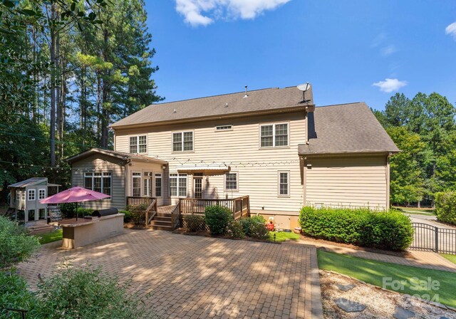 back of house with area for grilling and a wooden deck