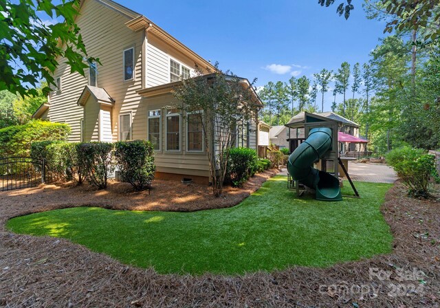 view of property exterior featuring a playground and a yard