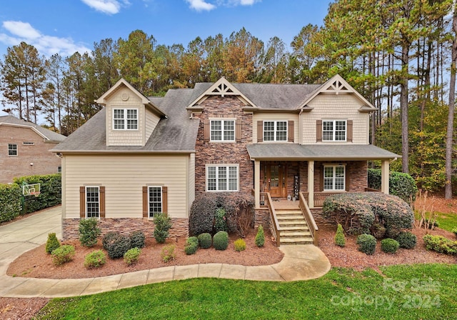 craftsman-style home featuring a porch and a wall unit AC