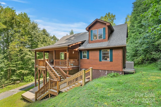 view of front of home featuring central air condition unit, a shingled roof, a front yard, and a wooden deck