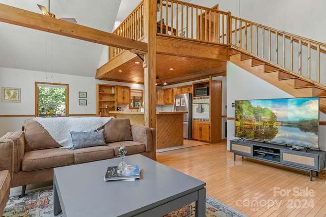 living room with high vaulted ceiling and light wood-type flooring