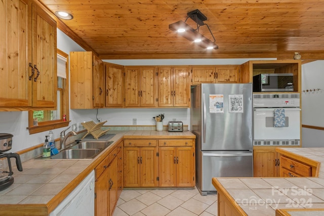 kitchen featuring appliances with stainless steel finishes, tile counters, and sink