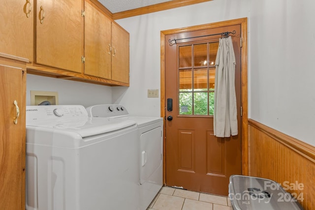 laundry room featuring a textured ceiling, cabinets, washer and clothes dryer, and light tile patterned floors