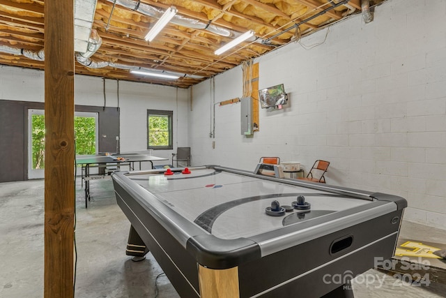 playroom featuring concrete flooring and electric panel