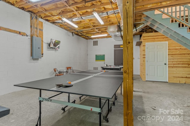 rec room with concrete flooring and electric panel