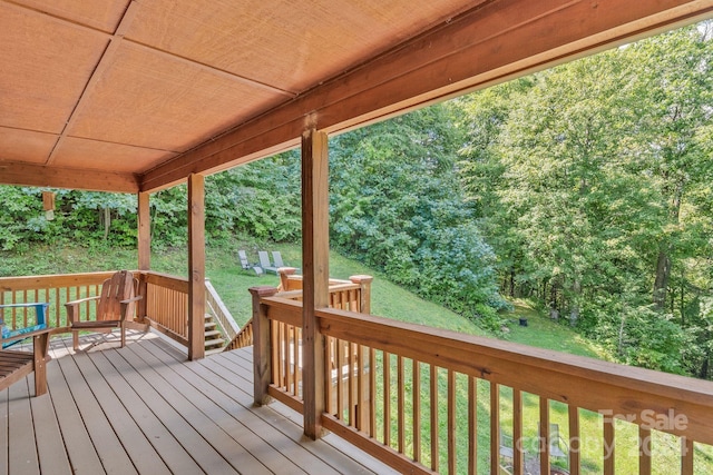 wooden deck featuring a lawn