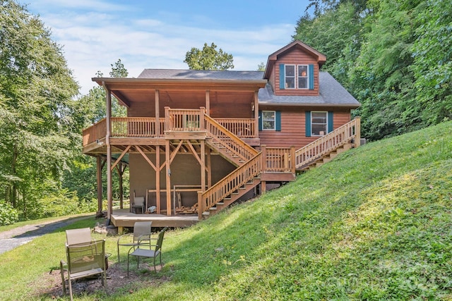 back of property featuring a lawn and a deck