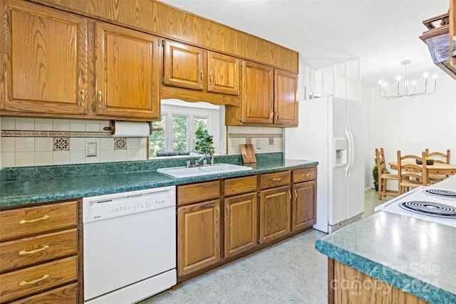 kitchen featuring white appliances, a chandelier, tasteful backsplash, and sink