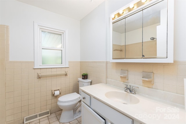 bathroom featuring vanity, tile walls, toilet, and tile patterned floors