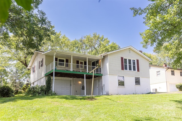 rear view of house featuring a yard, a garage, central AC, and a balcony