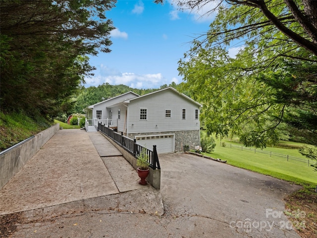 view of front of home with a front yard, fence, a garage, and aphalt driveway