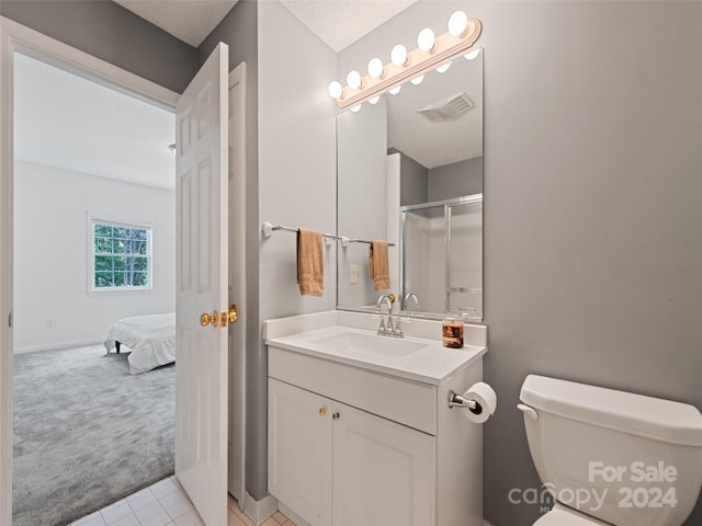 full bath featuring a shower with shower door, vanity, visible vents, and toilet