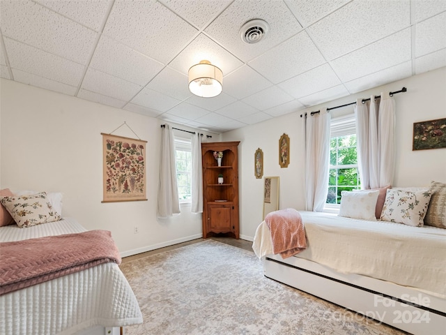bedroom with visible vents, baseboards, and a paneled ceiling