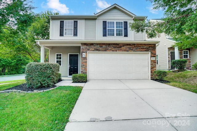 view of front of house with a garage and a front lawn