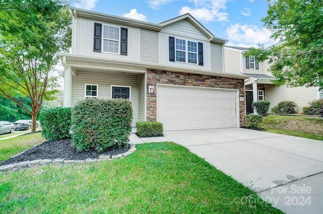 view of front of home featuring a front yard and a garage