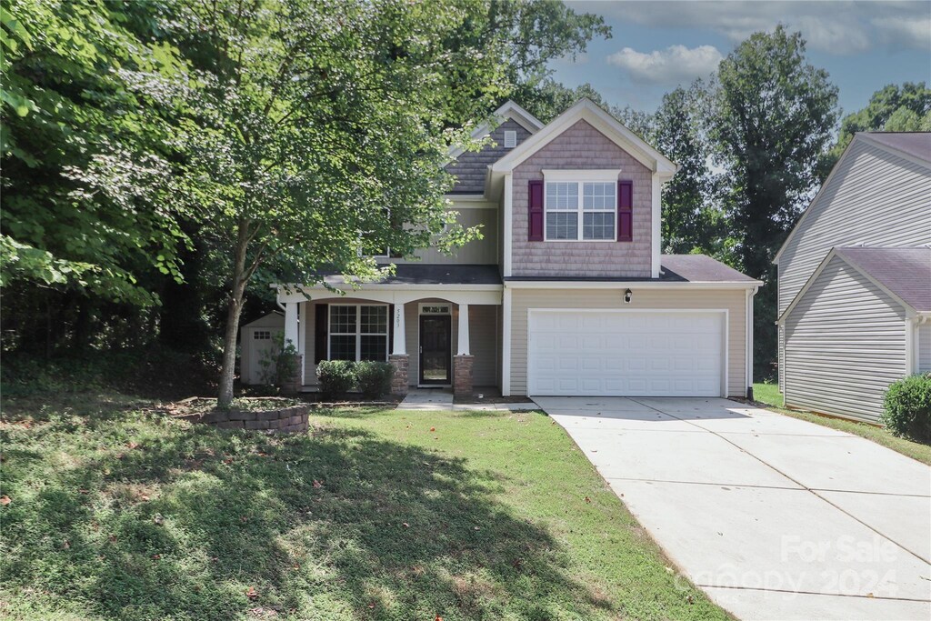 view of front of property with a garage and a front lawn