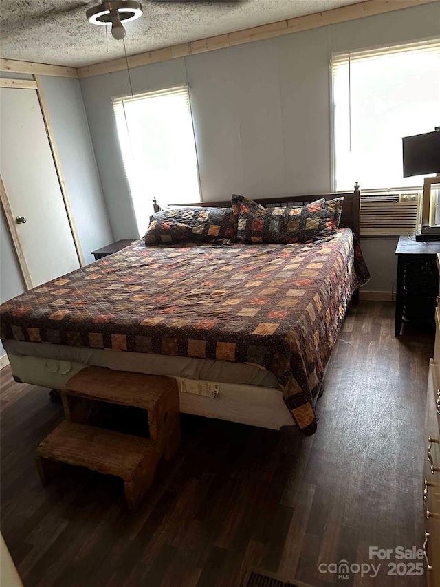 bedroom featuring ceiling fan, dark wood-type flooring, and a textured ceiling