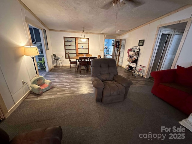 living room featuring a textured ceiling, ornamental molding, and hardwood / wood-style flooring