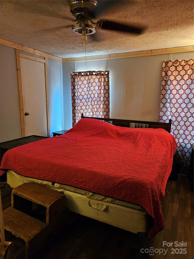 bedroom with ceiling fan, a textured ceiling, and wood-type flooring