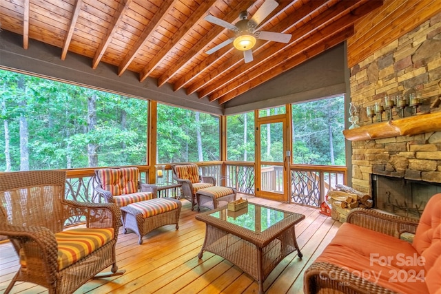 sunroom / solarium with wood ceiling, ceiling fan, a fireplace, and lofted ceiling with beams