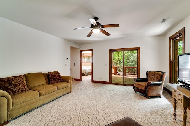 living room with light carpet, a wealth of natural light, and ceiling fan