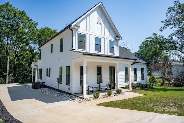 modern farmhouse featuring a porch and a front yard