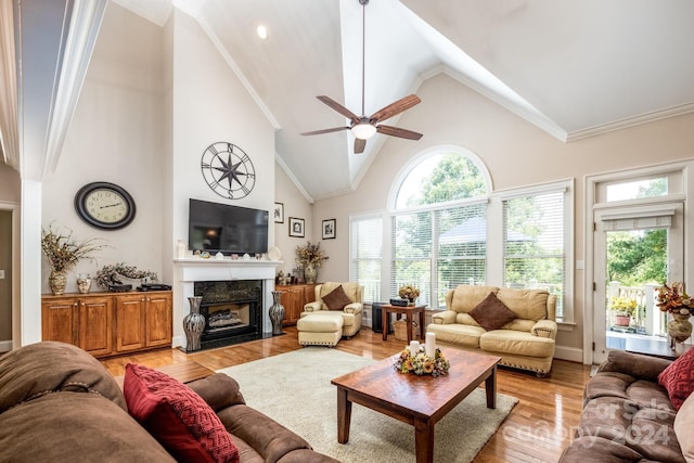 living room with crown molding, high vaulted ceiling, light hardwood / wood-style floors, and ceiling fan