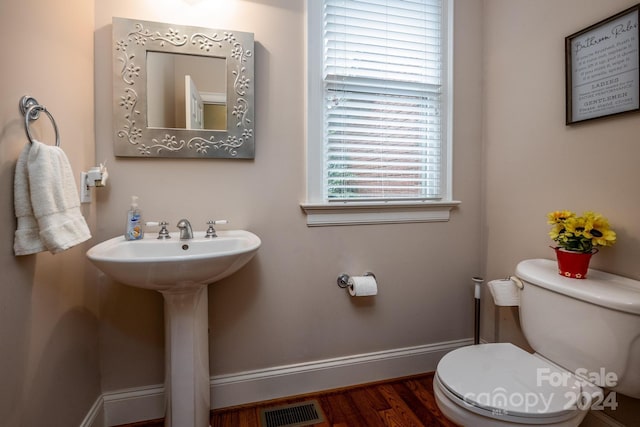 bathroom with toilet and hardwood / wood-style flooring