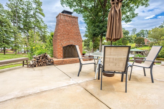 view of patio featuring an outdoor brick fireplace