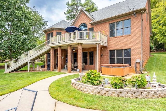 rear view of property with a hot tub, a yard, a patio, and a wooden deck