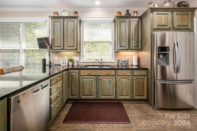 kitchen with dark stone countertops, stainless steel appliances, tasteful backsplash, and sink