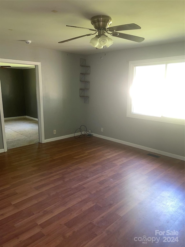 unfurnished room featuring ceiling fan and dark hardwood / wood-style floors