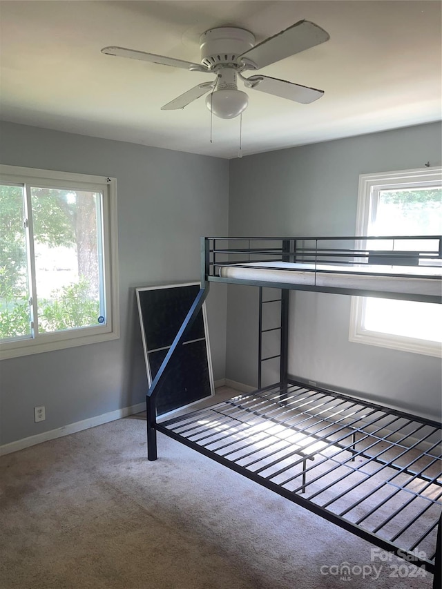 unfurnished bedroom with ceiling fan and carpet floors