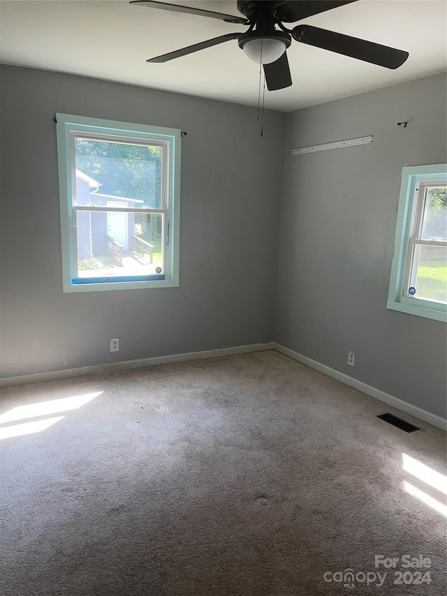 carpeted empty room featuring ceiling fan